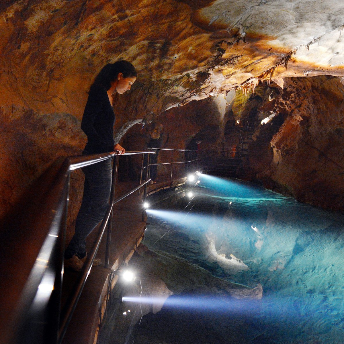 Woman looks at the water pool in River Cave at the Jenolan Caves at the Blue Mountains of New South Wales, Australia.