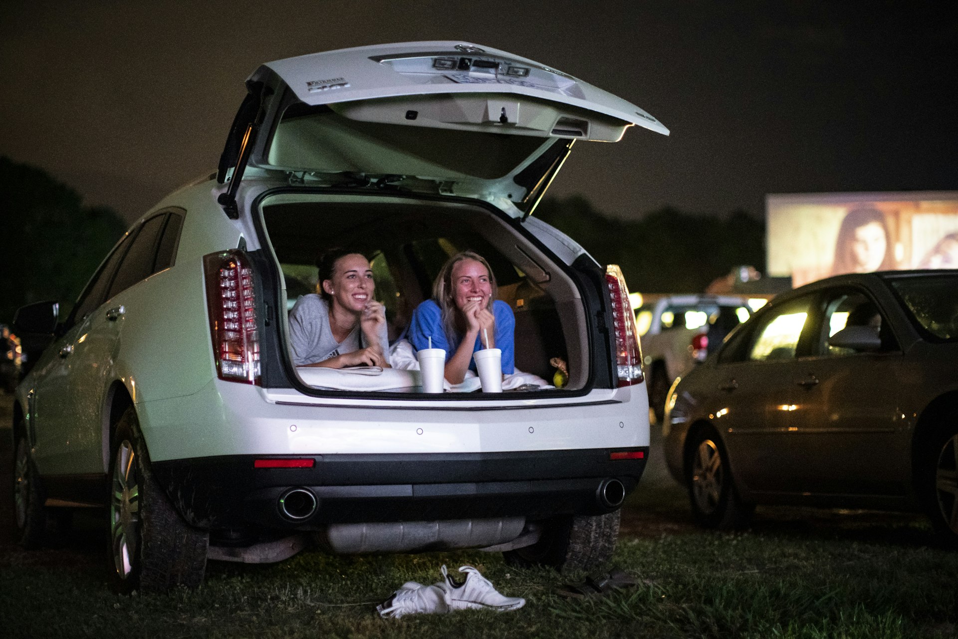 Two women watch a movie at the Badin Rd Drive-in from the trunk of their SUV. 