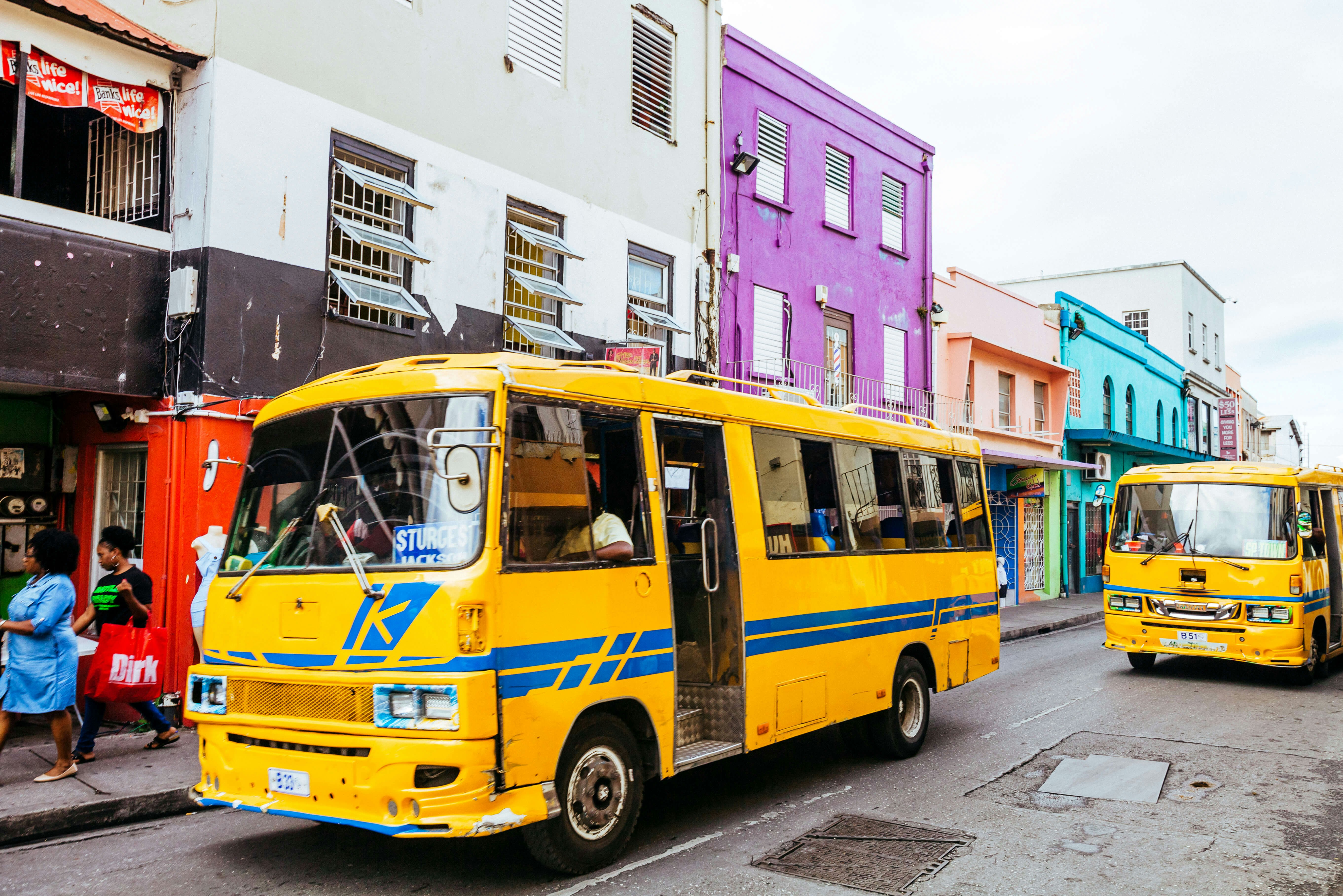 Everyday traffic scene with local yellow buses in the streets of old Bridgetown, Barbados