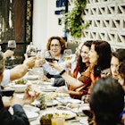 Multi-generational family toasting with wine glasses during dinner party in a restaurant in Mexico City