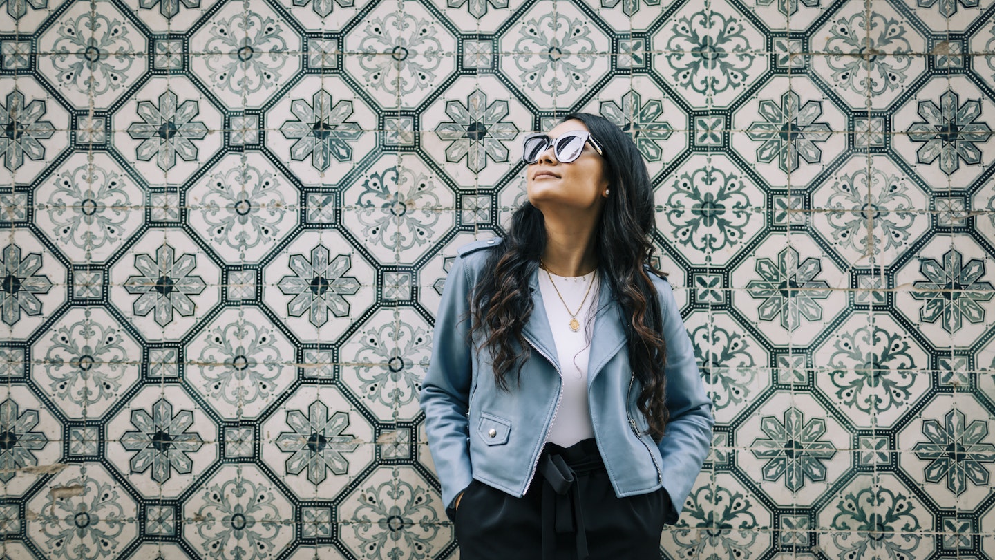 A woman standing in front of a tiled wall in Lisbon
