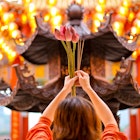An Asian woman offering fresh lotus flower and incense sticks at Thean Hou Temple, Kuala Lumpur