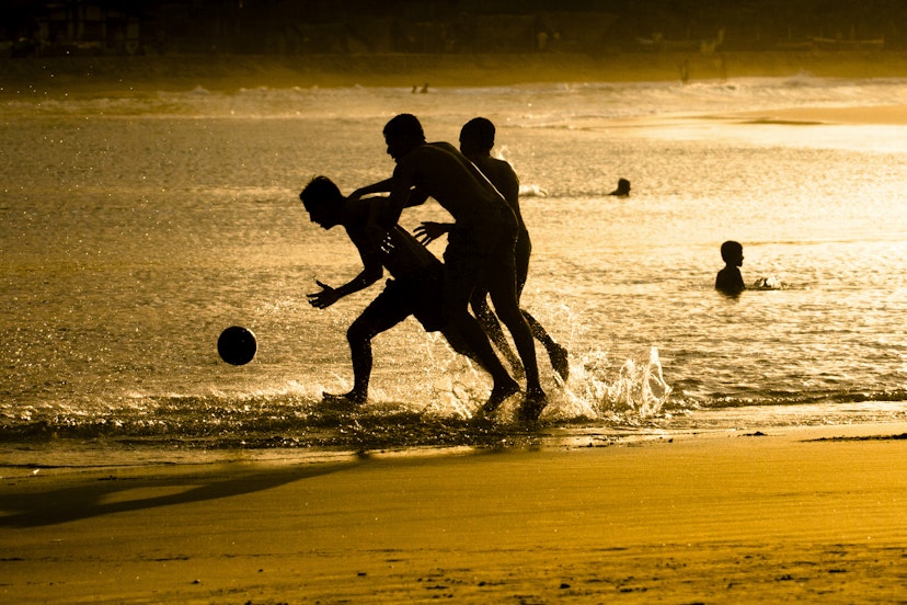 Silhouette of men playing football on the beach at Arugambay, Pottuvil, Sri Lanka
