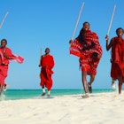 Four Maasai warriors running on the beach in Tanzania