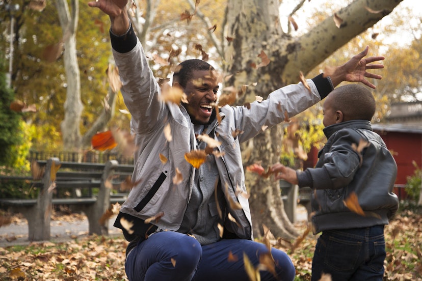 A father and son play in the fall leaves in New York state