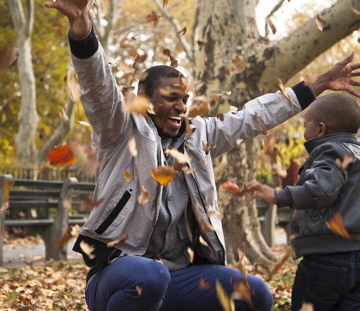A father and son play in the fall leaves in New York state
