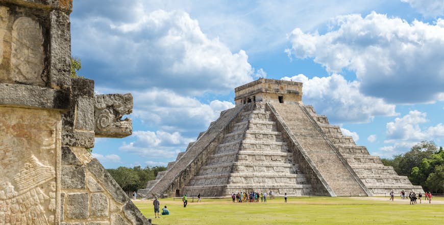 Visitors standing in front of a temple at Chichén Itzá, Mexico