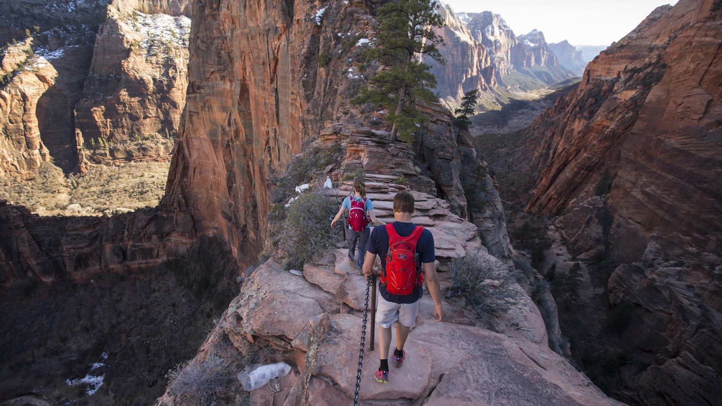 A man and woman hiking Angels Landing in Zion national Park.