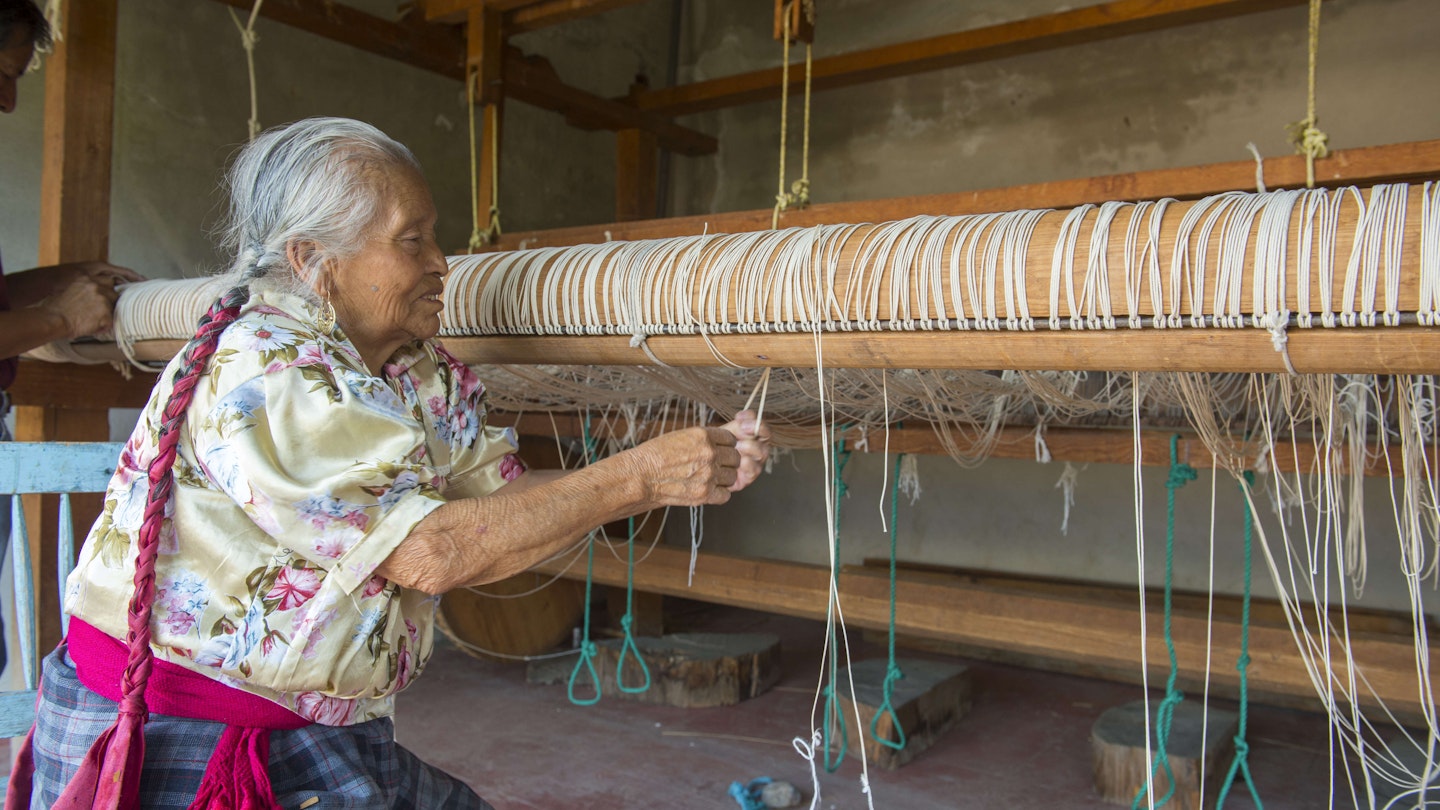 MEXICO - 2018/04/13: An old Zapotek woman is preparing a loom for weaving a carpet at a weavers home studio in Teotitlan del Valle, a small town in the Valles Centrales Region near Oaxaca, southern Mexico. (Photo by Wolfgang Kaehler/LightRocket via Getty Images)