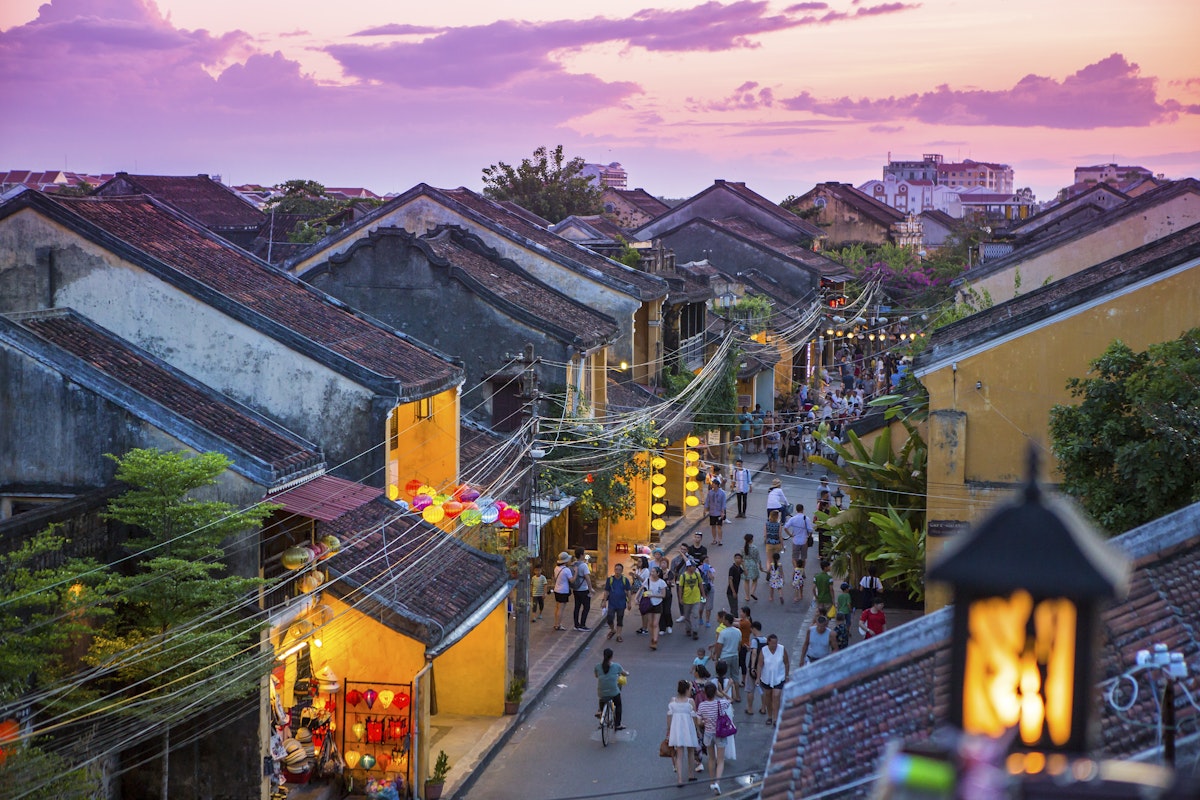 People walk down the colonial streets in historic old town Hoi An.
