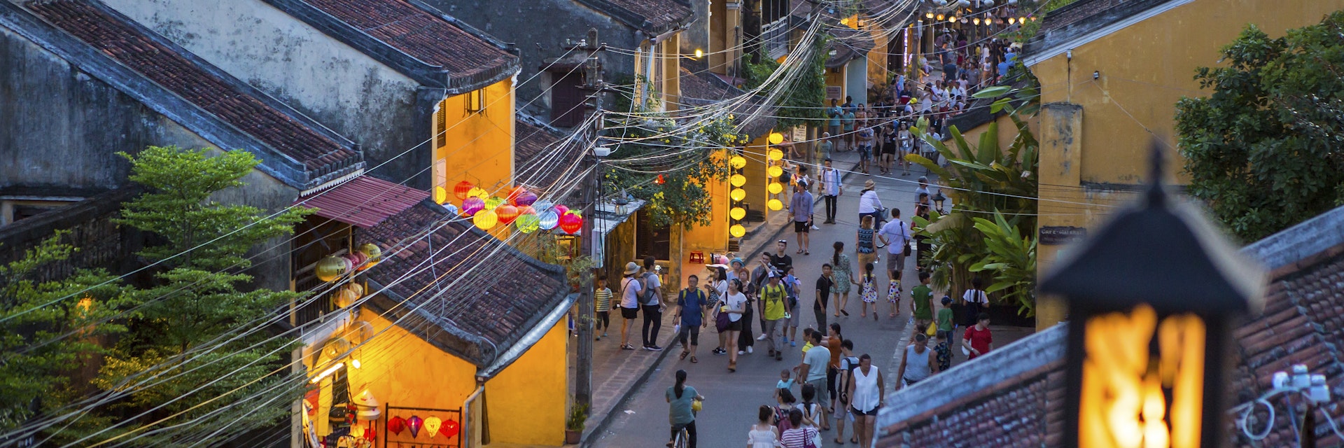 People walk down the colonial streets in historic old town Hoi An.