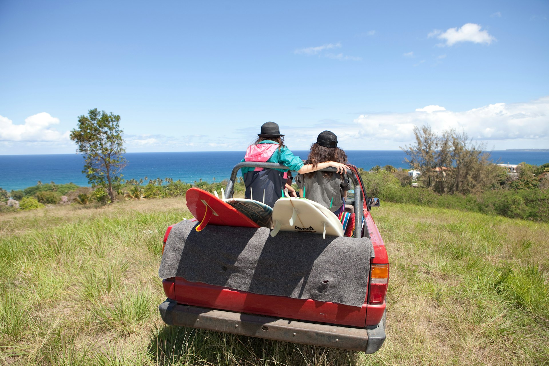 Off road vehicle driving toward beach with two women in back