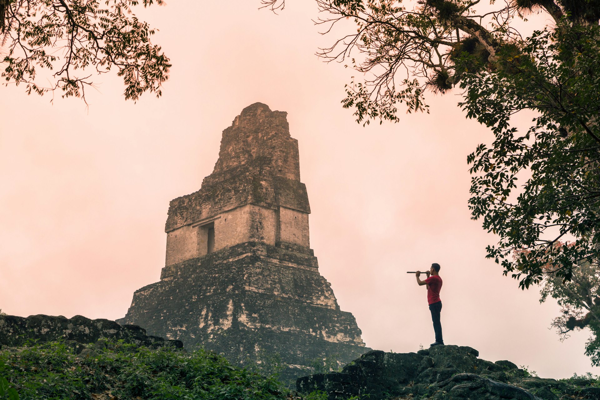 Man playing a flute at Tikal, Guatemala