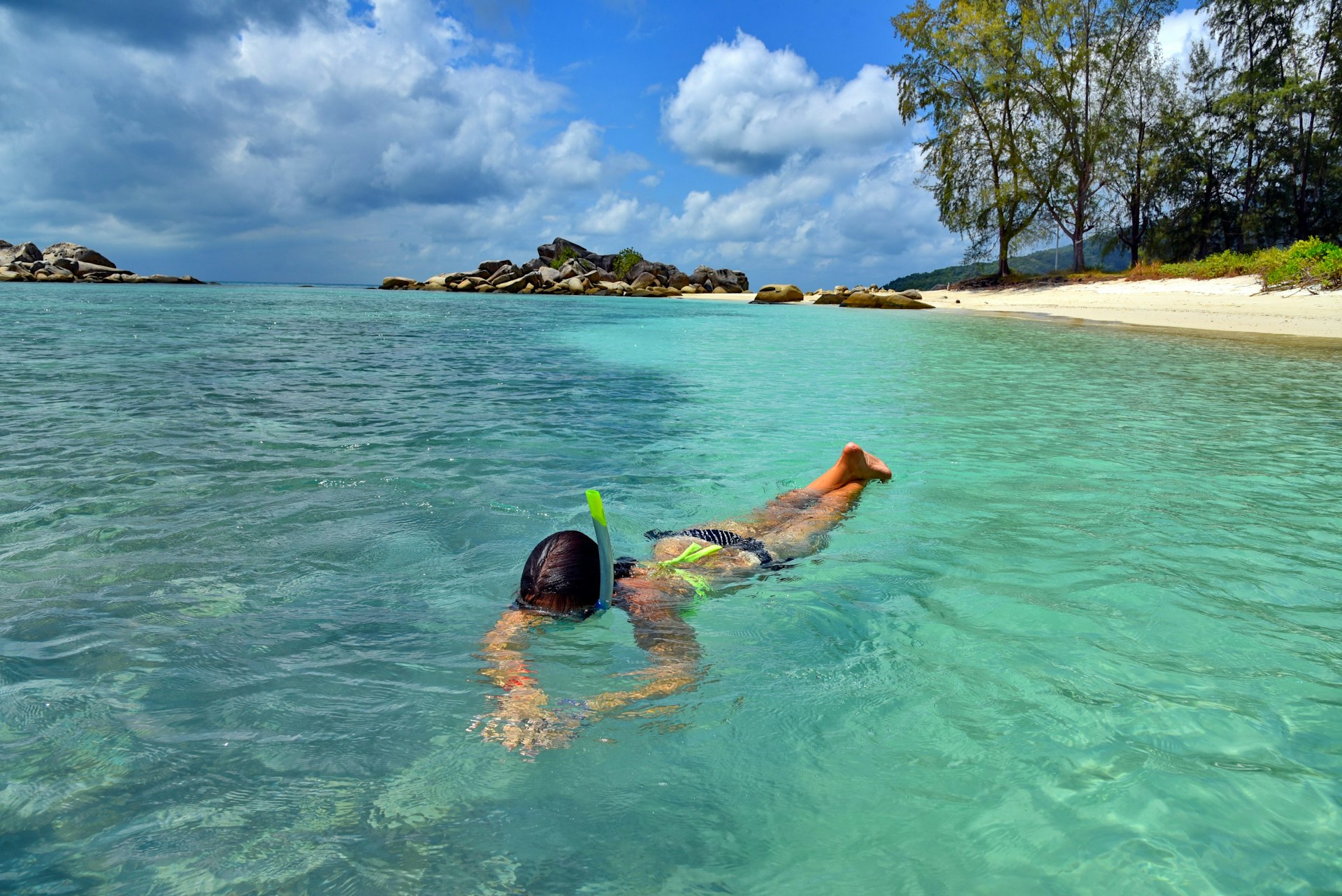 A woman snorkelling in a blue lagoon at Kecil Beach, Perhentian Islands