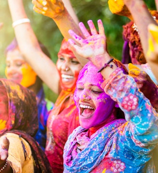 Indian women covered in colourful powder for Holi Festival in Jaipur.