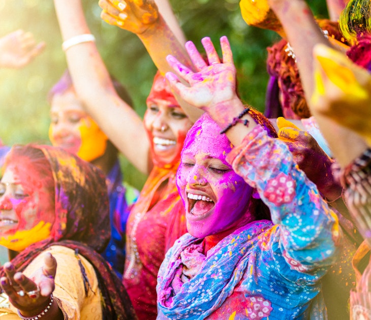 Indian women covered in colourful powder for Holi Festival in Jaipur.