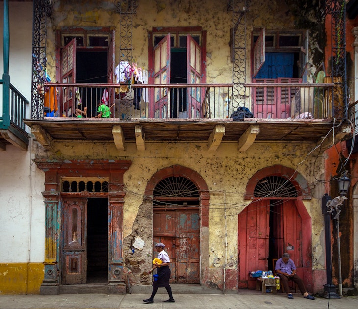 Panama City, Panama - September 12, 2013: Woman walking the streets and a vendor sleeping, in historic Casco Viejo district of Panama City, Panama.