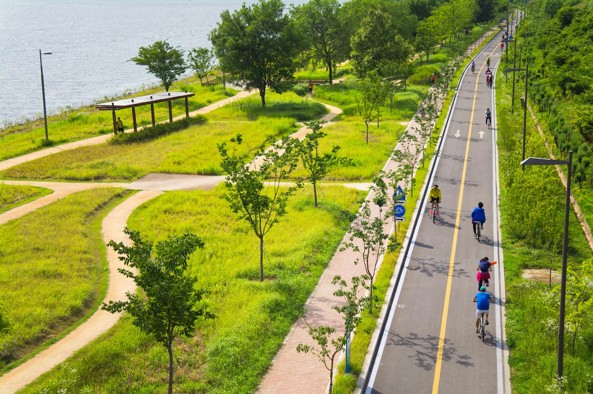Cyclists ride along a paved path in the Mangwon section of the riverside park along Han River, Seoul
