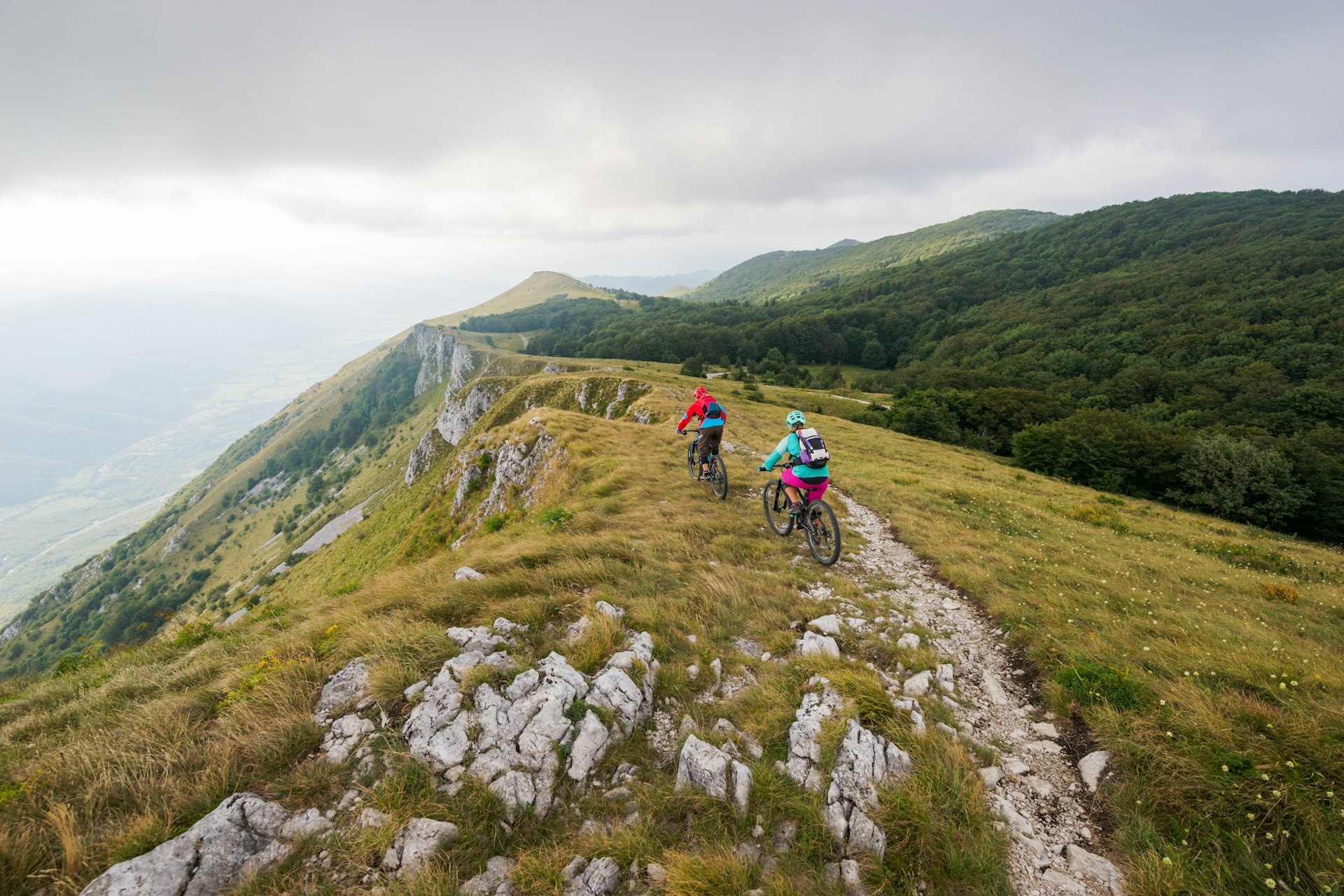 Two people mountain biking on a trail near Vipava, Slovenia