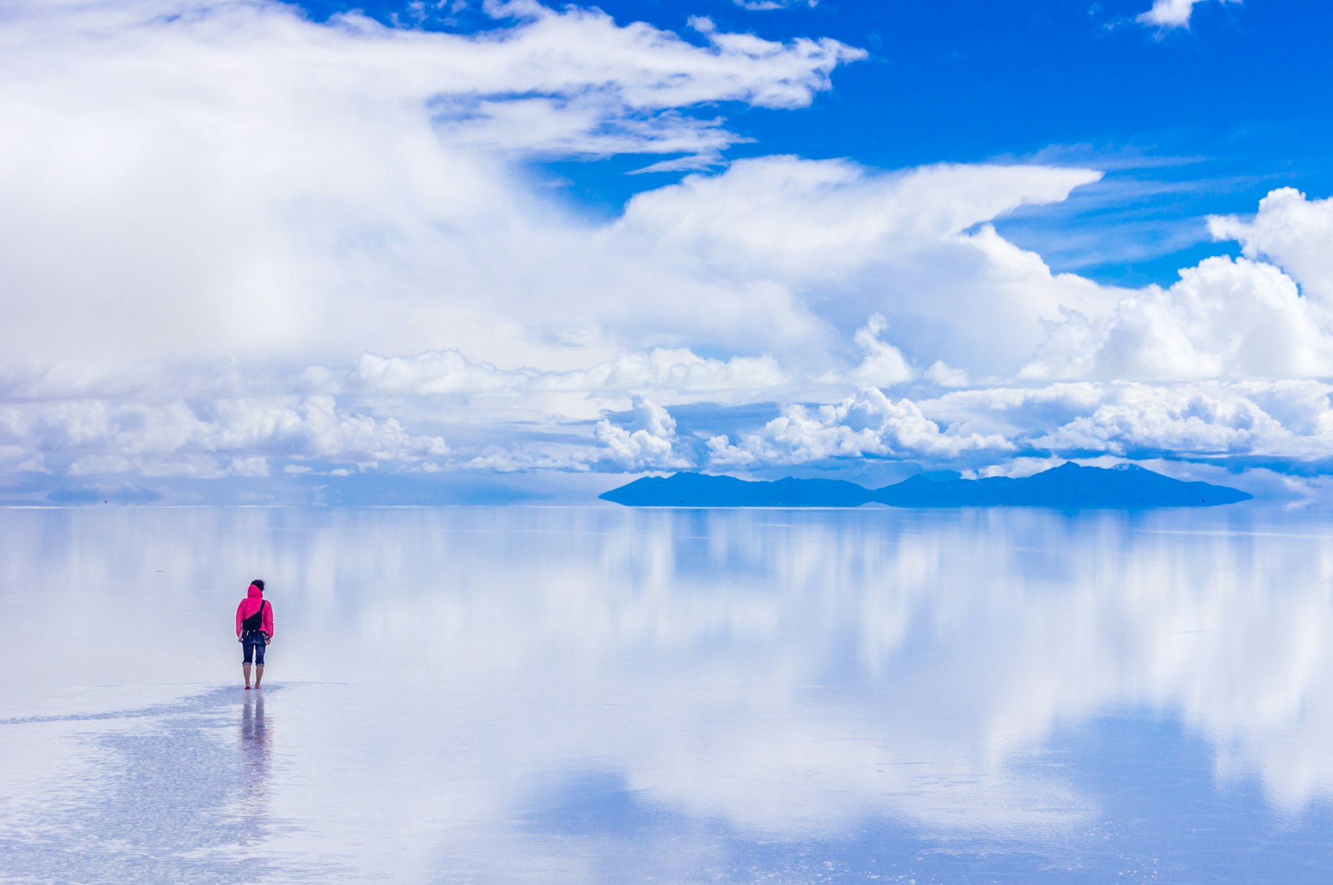 A traveler standing on the reflective salt flats of Salar de Uyuni 