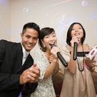 Three friends singing karaoke.