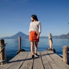 Hispanic woman on the pier of Lake Atitlan in Guatemala looking aside, full body