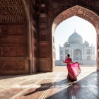 Woman in red saree/sari in the Taj Mahal, Agra, Uttar Pradesh, India; Shutterstock ID 1036002985; your: Claire Naylor; gl: 65050; netsuite: Online ed; full: Taj Mahal intro