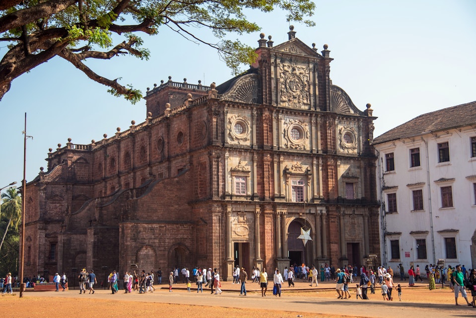 OLD GOA, INDIA - DECEMBER 27, 2018: Unidentified tourists visit the famous landmark - Basilica of Bom Jesus (Borea Jezuchi Bajilika) in Old Goa, India. Basilica is a UNESCO World Heritage Site.