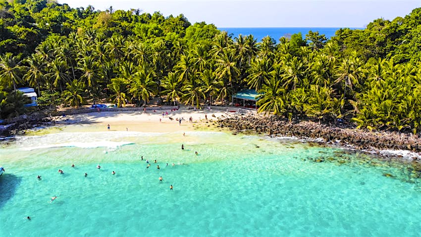 Aerial view of beautiful landscape, tourism boats, and people swimming on the sea and beach on May Rut island (a tranquil island with beautiful beach) in Phu Quoc, Kien Giang, Vietnam. Aerial view of May Rut beach in Phu Quoc, Vietnam