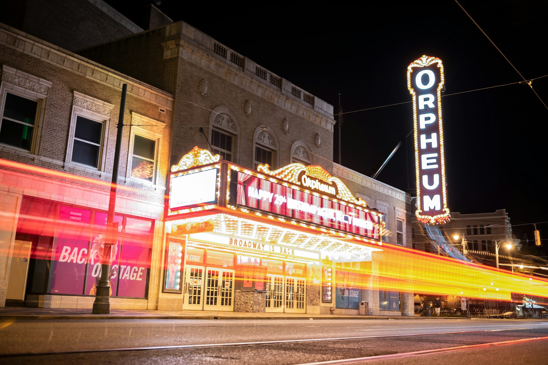 The neon frontage of a theater, with a large lit-up vertical sign that says "Orpheum" 