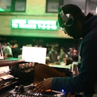 A DJ wearing headphones while scratching a record during a party at Central Station in Memphis. 