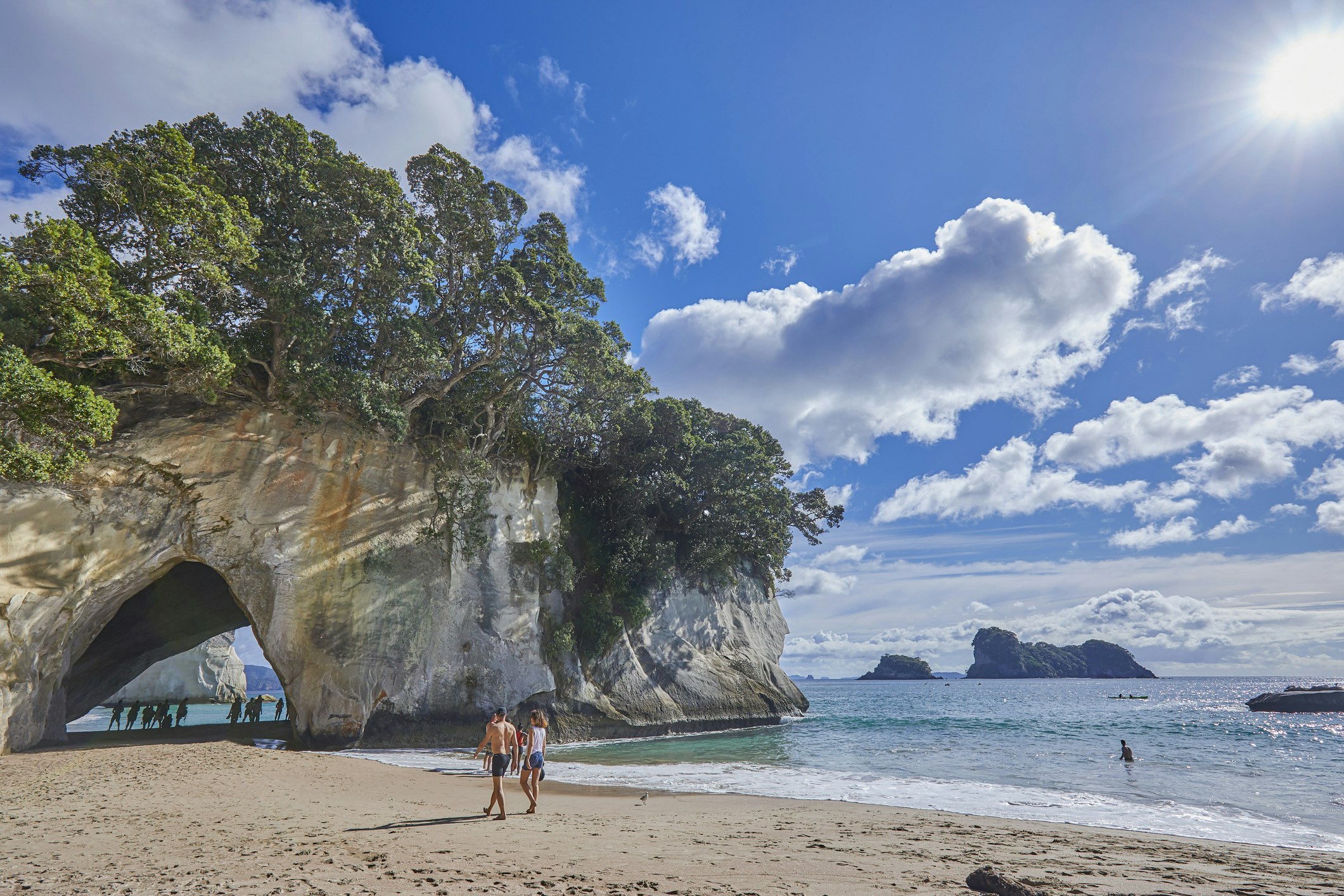 A huge rock archway is a distinctive feature on a sandy beach