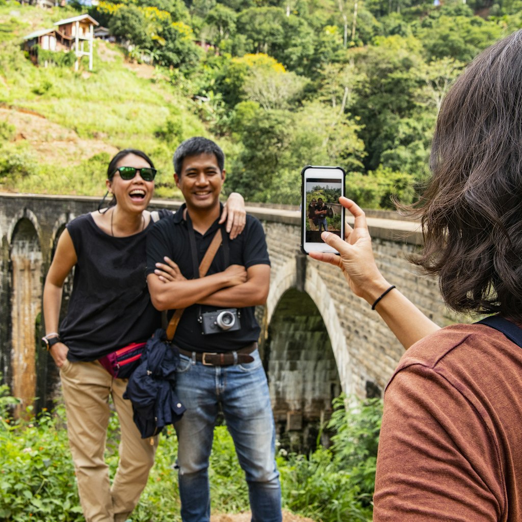 woman taking a picture of her friends at the iconic Nine Arch Bridge