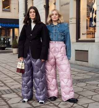 STOCKHOLM, SWEDEN - FEBRUARY 08: Linn Eklund and Fanny Ekstrand are seen wearing purple and pink Miu Miu quilted nylon pants outside Beckmans college of design show in Stockholm fashion week Autumn/Winter 2022 on February 08, 2022 in Stockholm, Sweden. (Photo by Raimonda Kulikauskiene/Getty Images)