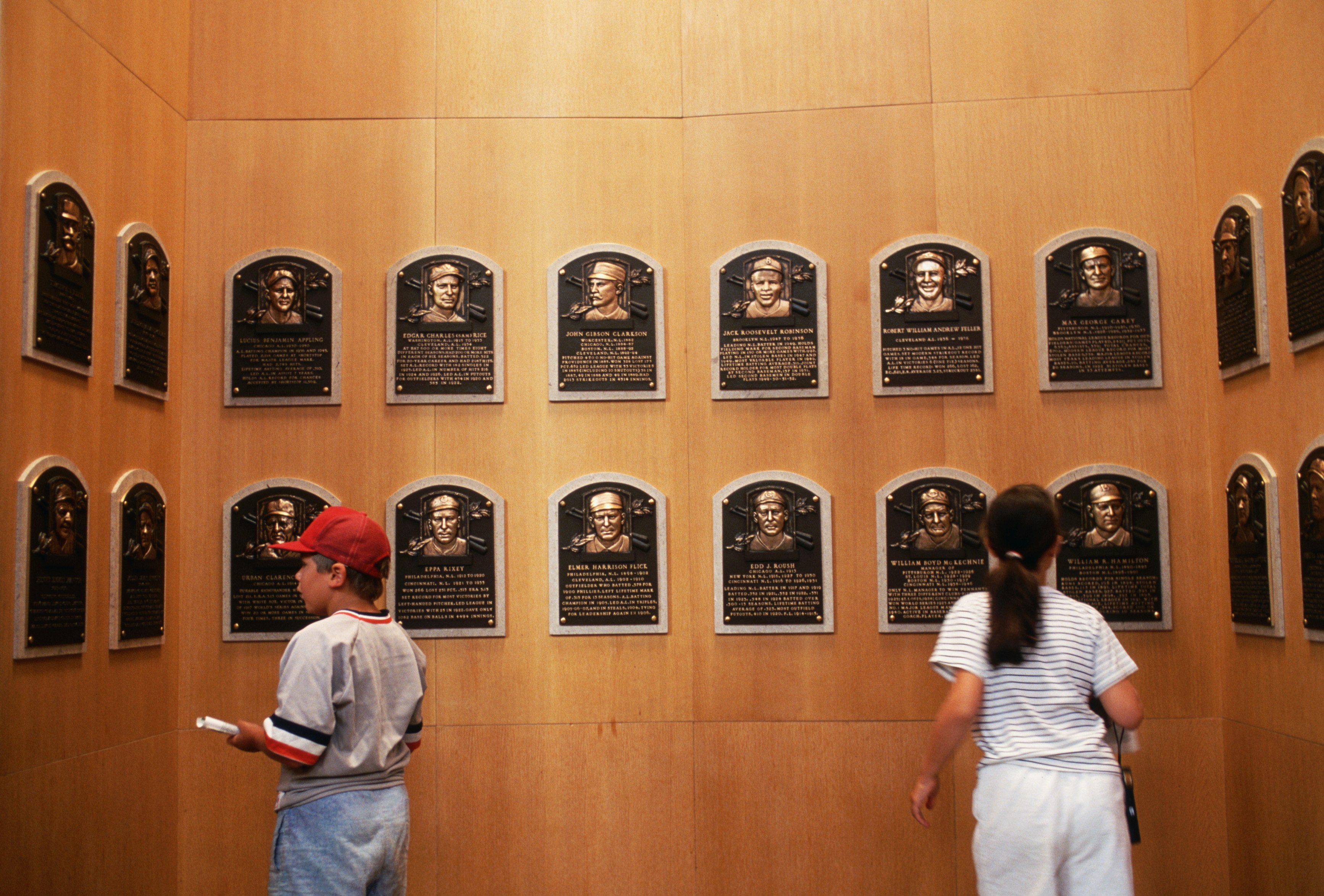 A young boy and girl look at name plaques of baseball players who have been inducted into the Baseball Hall of Fame