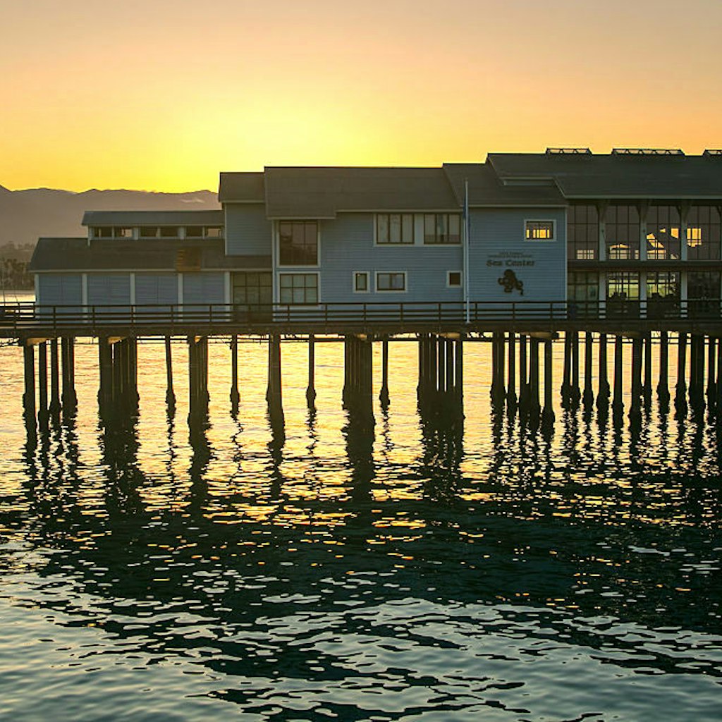 The sun rises behind the Museum of Natural History Sea Center at Stearns Wharf 