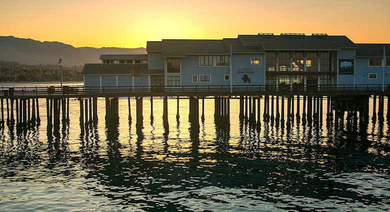 The sun rises behind the Museum of Natural History Sea Center at Stearns Wharf 