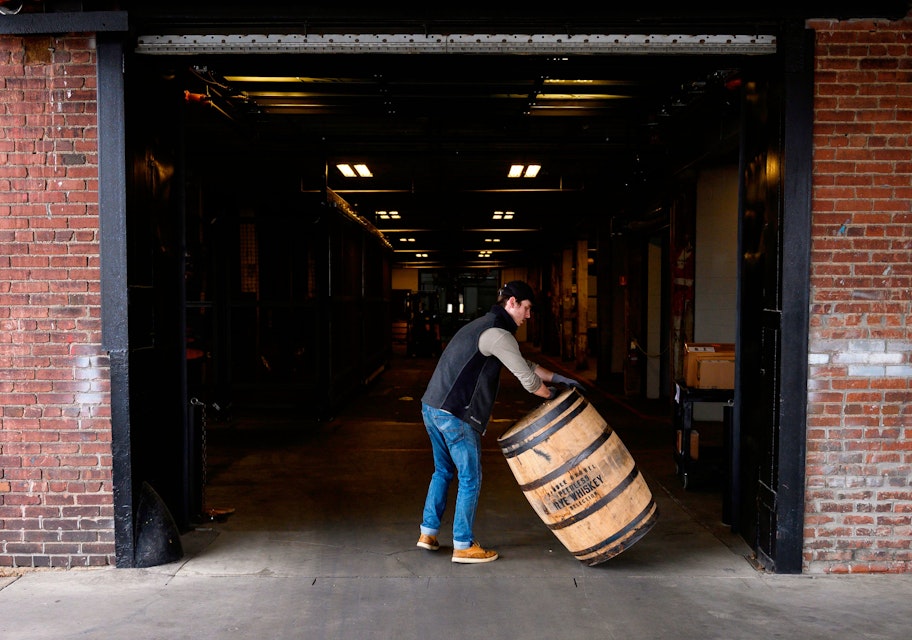 Jarrod Rampy rolls a barrel for bourbon into the Kentucky Peerless Distilling company in Louisville, Kentucky on April 11, 2019. - To be called Bourbon in the United States the whiskey mash contents require a minimum of 51 percent corn and stored in a new barrel lined with charred oak. After Canada, China, Mexico and the European Union slapped import duties from 10 to 25 percent on US whiskey and bourbon in 2018, exports dropped over 12 percent in the second quarter. (Photo by Andrew CABALLERO-REYNOLDS / AFP)        (Photo credit should read ANDREW CABALLERO-REYNOLDS/AFP via Getty Images)