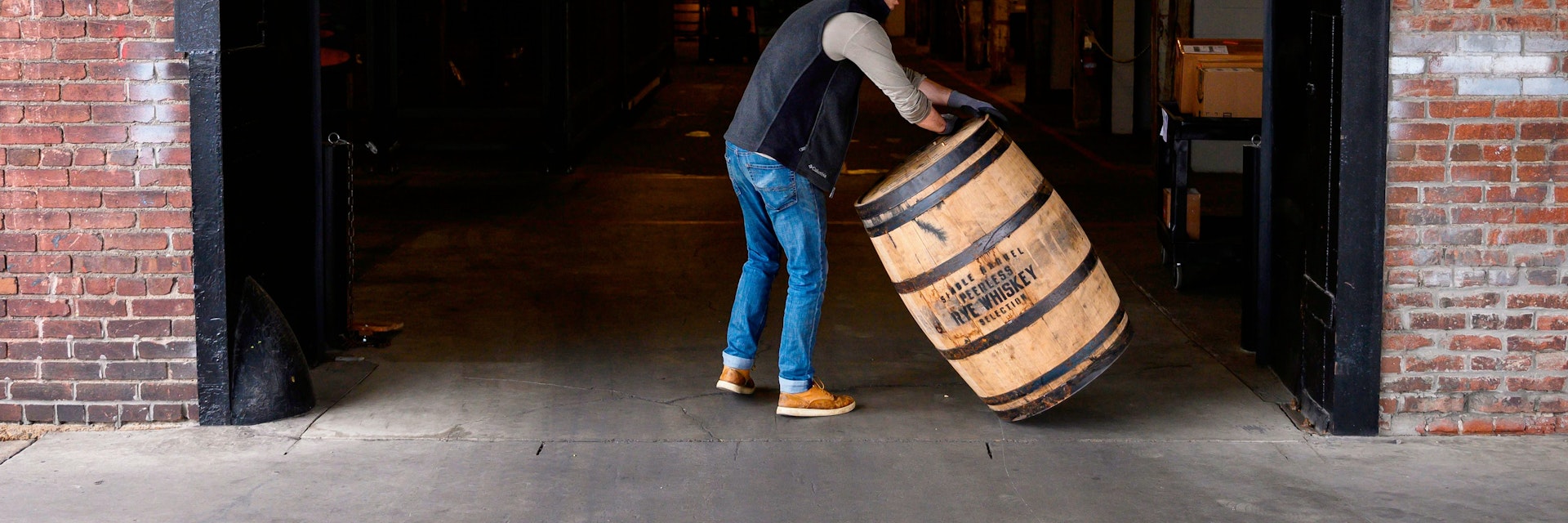 Jarrod Rampy rolls a barrel for bourbon into the Kentucky Peerless Distilling company in Louisville, Kentucky on April 11, 2019. - To be called Bourbon in the United States the whiskey mash contents require a minimum of 51 percent corn and stored in a new barrel lined with charred oak. After Canada, China, Mexico and the European Union slapped import duties from 10 to 25 percent on US whiskey and bourbon in 2018, exports dropped over 12 percent in the second quarter. (Photo by Andrew CABALLERO-REYNOLDS / AFP)        (Photo credit should read ANDREW CABALLERO-REYNOLDS/AFP via Getty Images)