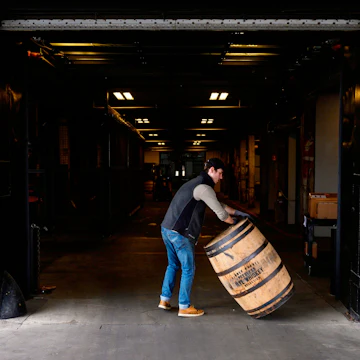 Jarrod Rampy rolls a barrel for bourbon into the Kentucky Peerless Distilling company in Louisville, Kentucky on April 11, 2019. - To be called Bourbon in the United States the whiskey mash contents require a minimum of 51 percent corn and stored in a new barrel lined with charred oak. After Canada, China, Mexico and the European Union slapped import duties from 10 to 25 percent on US whiskey and bourbon in 2018, exports dropped over 12 percent in the second quarter. (Photo by Andrew CABALLERO-REYNOLDS / AFP) (Photo credit should read ANDREW CABALLERO-REYNOLDS/AFP via Getty Images)