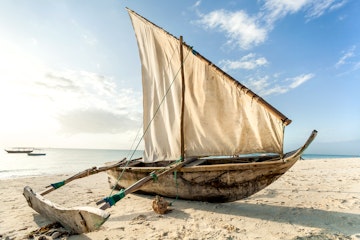 A Dhow boat on the beach. Sailing boat on the shore.