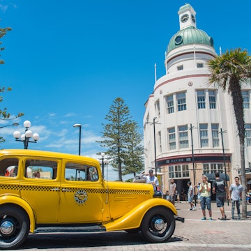 Napier, New Zealand -December-30-2017 : The classic cars tour parked in front of T&G building an iconic art deco landmark building in Napier town, New Zealand.