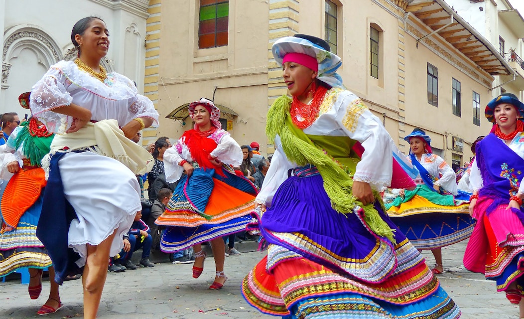 Cuenca, Ecuador - December 24,2018: Christmas parade Pase Del Niño Viajero (Traveling Child) in honor of baby Jesus. Group of folk dancers in costumes Otavalo and Cayambe people at the historical center of city