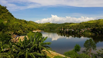River and green hills. Beautiful natural scenery of river in southeast Asia. Countryside on a large tropical island. Small village on the green hills by the river. The nature of the Philippines, Samar