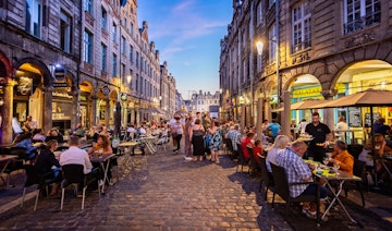 Busy outdoor street cafes at sunset on the cobblestones of Arras, Pas de calais, France on 30 September 2019