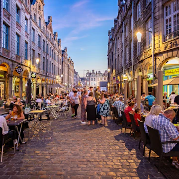 Busy outdoor street cafes at sunset on the cobblestones of Arras, Pas de calais, France on 30 September 2019