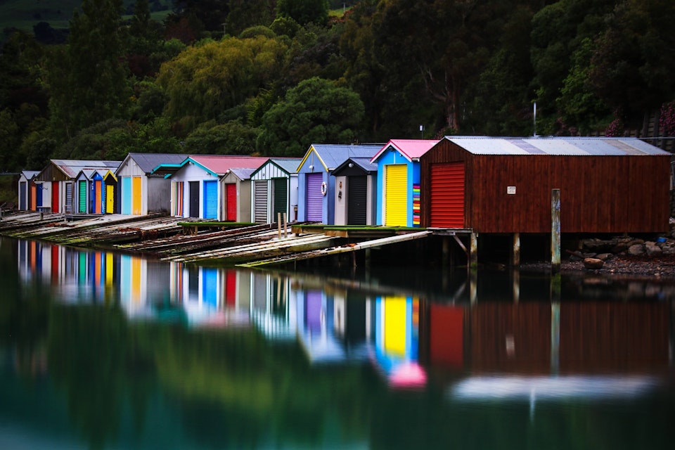 A calm, perfect morning capturing the colourful reflections of the duvauchelle Boat sheds