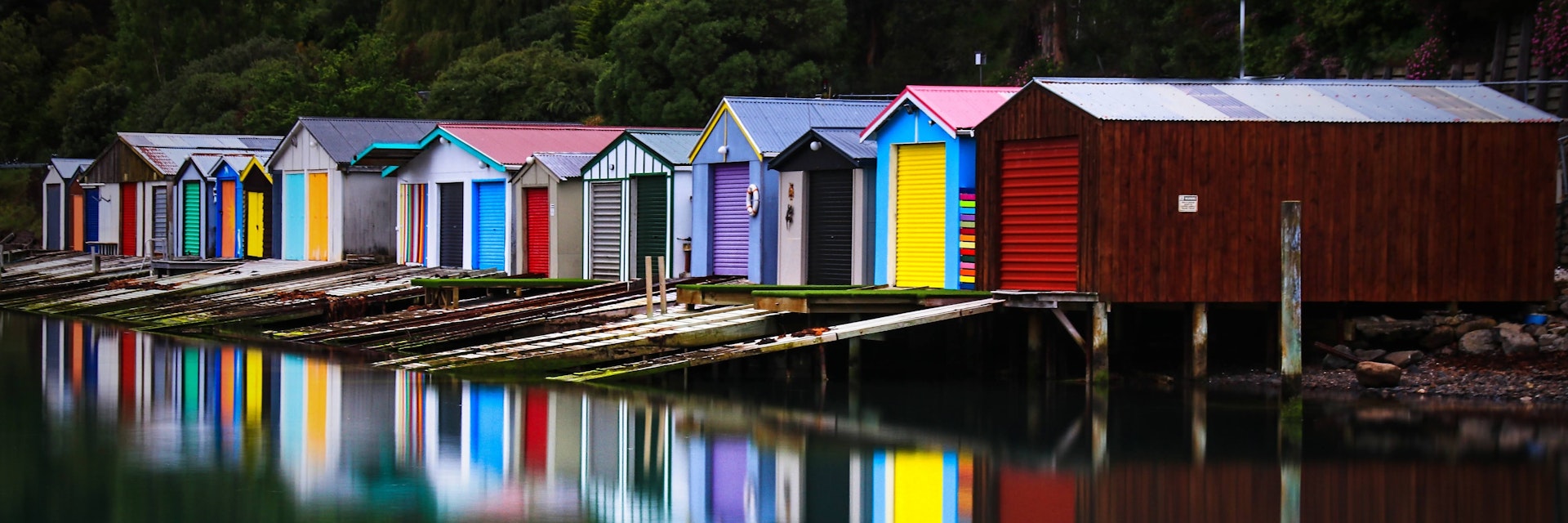 A calm, perfect morning capturing the colourful reflections of the duvauchelle Boat sheds