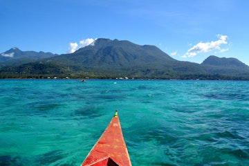 Transparent turquoise water at the Idyllic White Island with the volcanic landscape of Camiguin in the background.