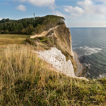 Panoramic shot made up of 4 vertical frames stitched together of the  landscape view of the famous chalk cliffs at Møns Klint on the island of Møn, Denmark. The cliffs run for 8 km along the coast ranging in height from a few meters above sea level to over 120m. The area is a popular destination for holiday makers looking for some adventure with lots of hiking trails, mountain bike tracks, sea kayaking and sport fishing activites all catered for. The tall slim tower almost hidden in the trees is a relic of the Cold War, it was an early warning radar station, that due to it's location in the Baltic  could "see" into Russian airspace, now it is used to monitor shipping.